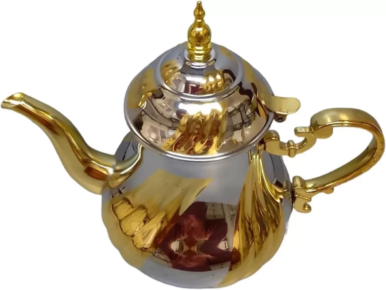 إبريق شاي أنيق باللونين الفضي والذهبي يتميز بفوهة منحنية ومقبض معقد، على خلفية بيضاء. مثالي لتقديم مجموعة متنوعة من أنواع الشاي. إضافة مثالية لعشاق الشاي على مدونتنا!